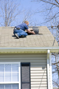 Roofing contractor repairing roof on home after recent wind storms many roofs were damaged