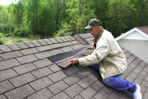 Roofer working on damaged shingle roof