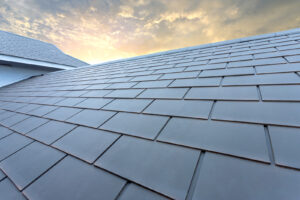 Slate roof against blue sky, Gray tile roof of construction house with blue sky and cloud of the sunset background