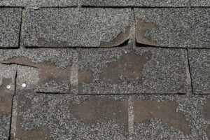 Roof in need of repair damaged asphalt roofing shingles architecture construction background texture pattern abstract concept