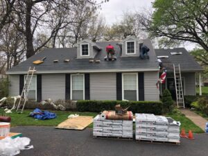 Roofers working on a suburban home roof replacement