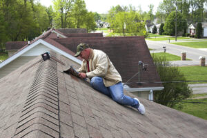 Roofer repairing damaged shingles after storm with very high winds came through over night