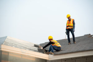 Two roofing contractors on top of a roof