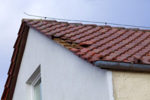 Home Roof Damage After Storm. Fallen Shingles On House