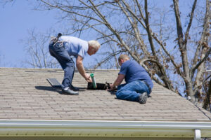 Roofing contractor repairing damaged roof on home after recent wind storms many roofs were damaged